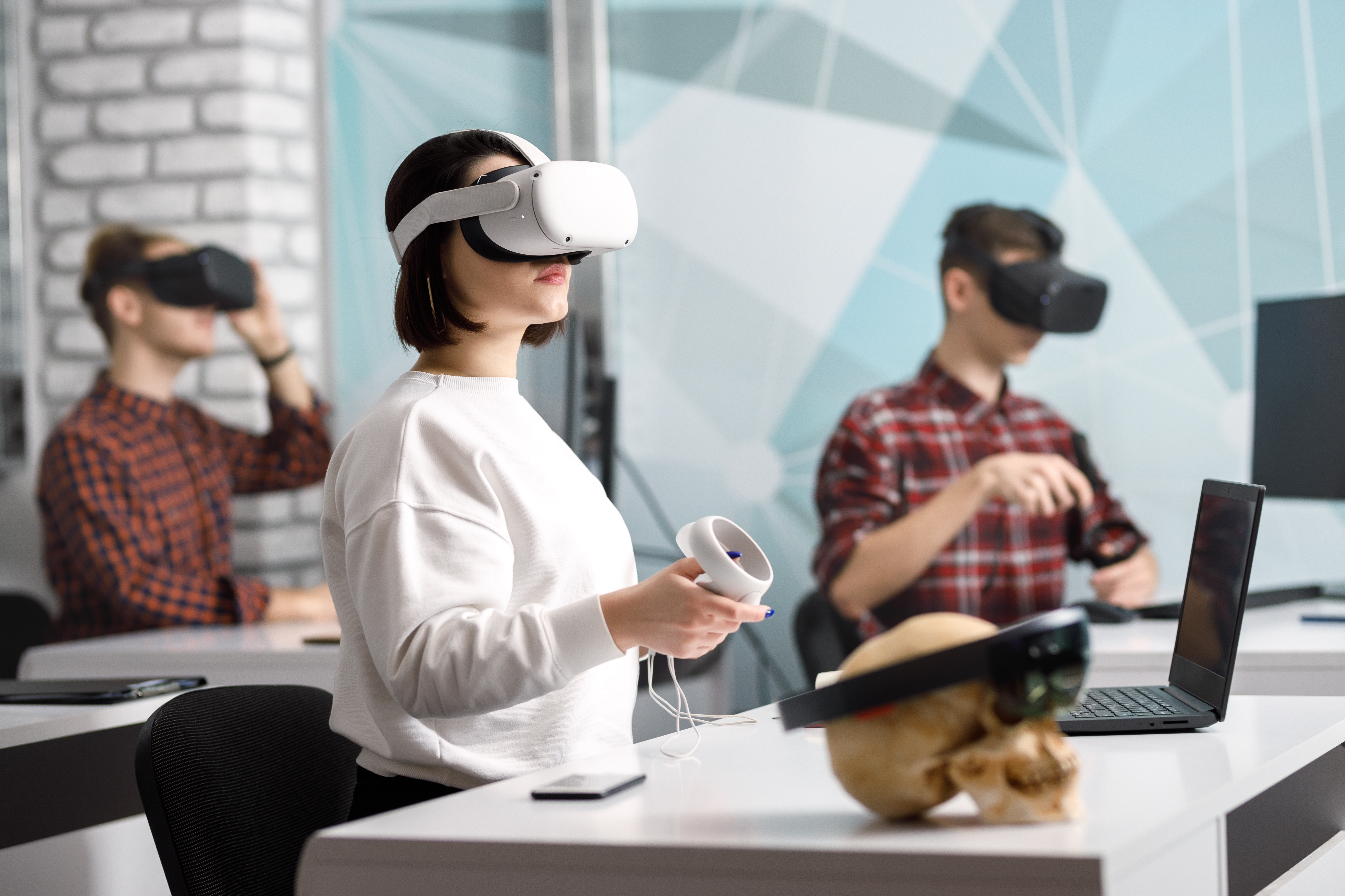 People using smart glasses and VR headsets in a collaborative workspace, showcasing next-generation AR and XR devices.