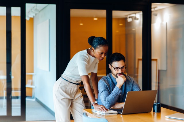 Business leaders analyzing AI-driven research insights with human oversight in a collaborative office setting