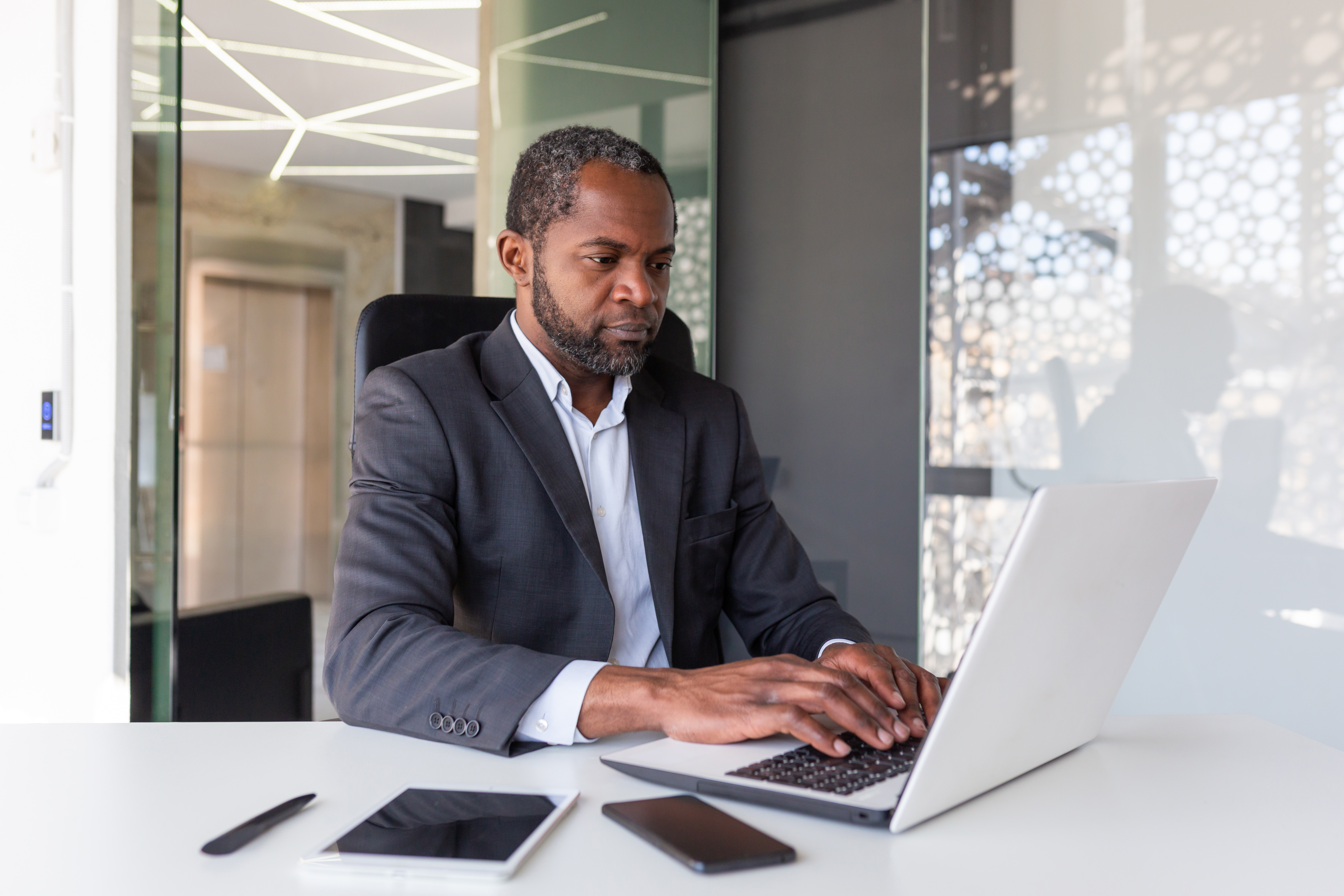 Business professional using laptop and mobile devices for digital commerce and data-driven decisions
