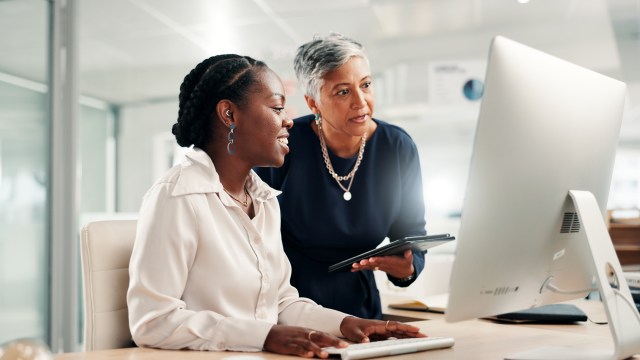 Diverse team collaborating with digital technology in a modern workplace, representing AI-enabled digital accessibility