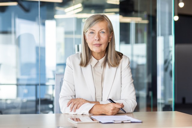Senior business executive seated at a conference table in a modern office, representing C-suite leadership in agentic AI deployment strategy